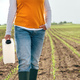 Corn crop protection concept, female farmer agronomist holding jerry can container canister - PhotoDune Item for Sale