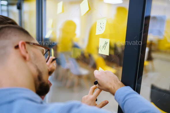 Young business people discussing and planning strategy Front of glass wall marker and stickers.