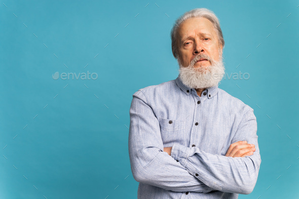 Portrait angry old man white bearded pensioner unhappy mad crazy conflict disagreement over blue