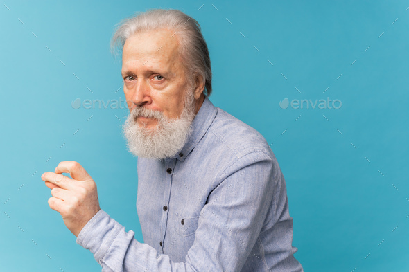 Portrait angry old man white bearded pensioner unhappy mad crazy conflict disagreement over blue