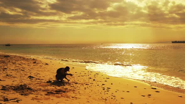 Catching fish for cute guy on holiday enjoying activities at beach on summer white sandy and blue ba alt