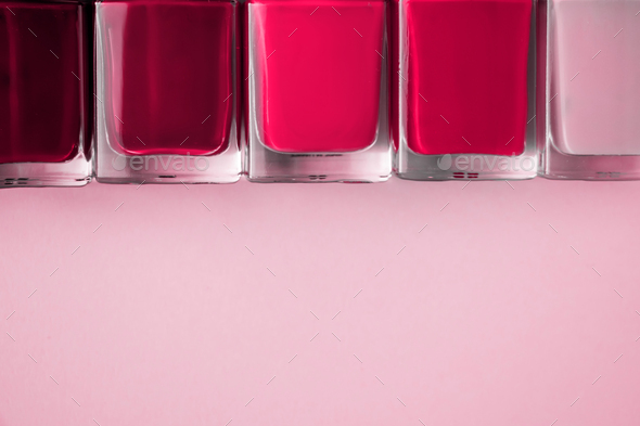 Nail polishes on pink background. Color of the year 2023 - Viva Magenta