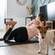 Cute dog near woman doing fitness exercises at home - PhotoDune Item for Sale