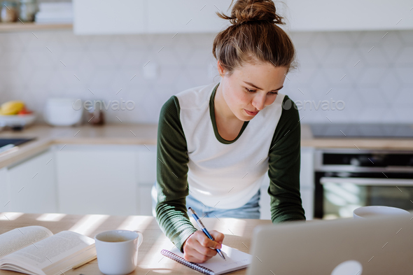 Young woman having homeoffice in her kitchen. - Stock Photo - Images