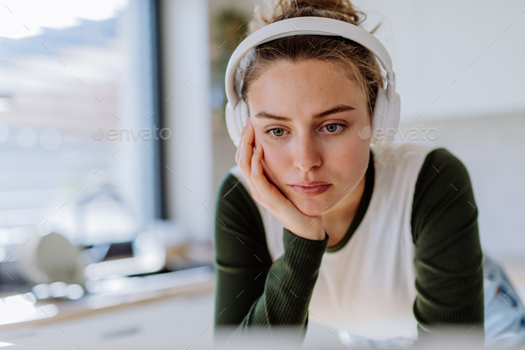 Portrait of young woman having homeoffice in her kitchen. - Stock Photo - Images