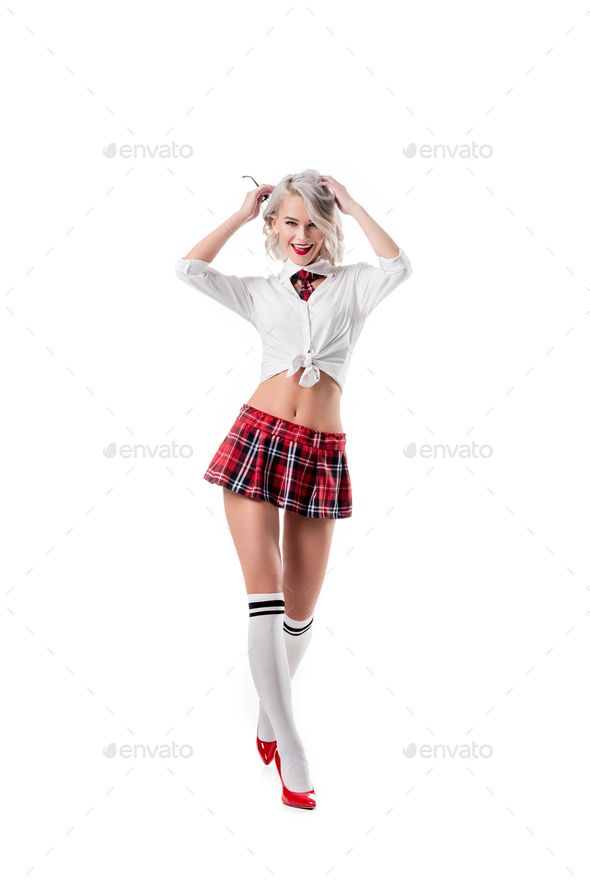 sexy playful woman in short schoolgirl plaid skirt and knee socks with eyeglasses posing isolated on