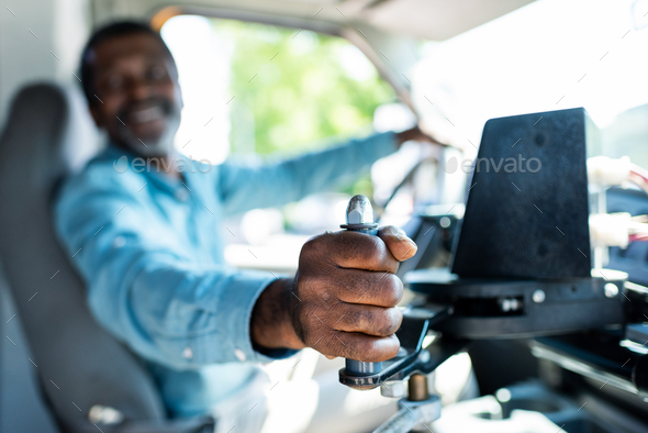 selective view shot of mature african american bus driver pulling lever at bus