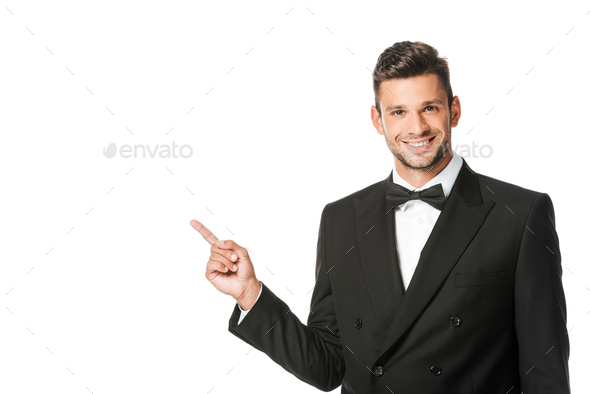 happy young man in suit pointing at blank space isolated on white