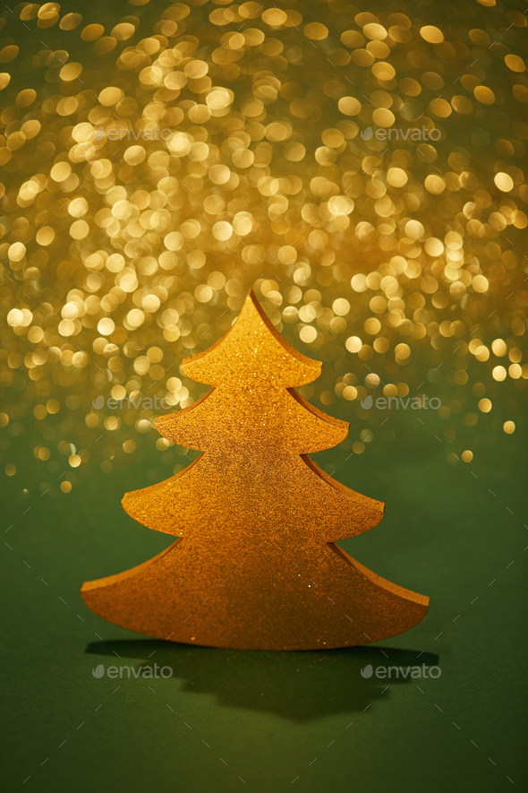 golden glittering christmas tree for decoration on green background