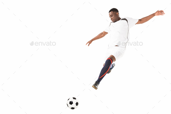 young african american soccer player kicking ball in jump isolated on white