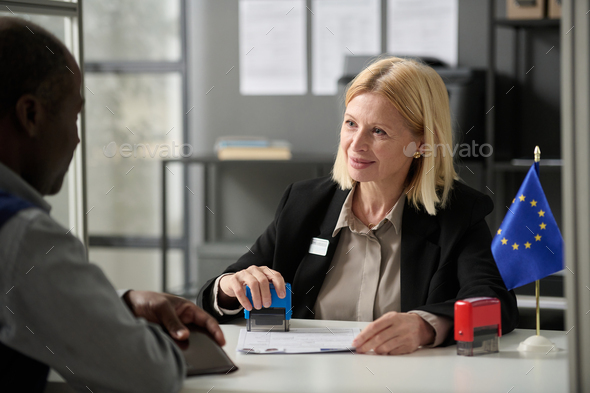 Mature woman consulting person in EU immigration office