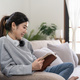 Young beautiful asian woman student sitting on sofa reading book at home. - PhotoDune Item for Sale