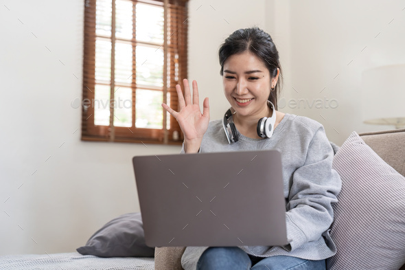 Friendly woman waving her hand in online meeting - Stock Photo - Images