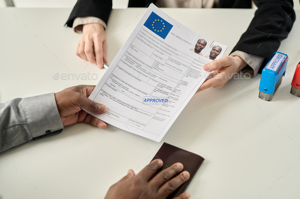 Top view of black man holding approved visa