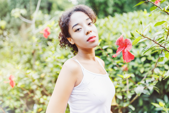 Young African American mixed race woman in garden. White shirt mock up