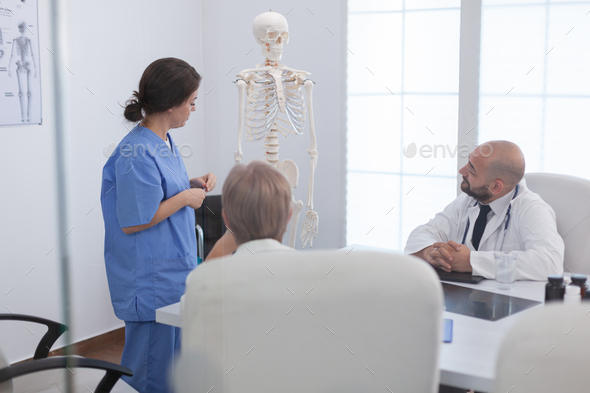 Medical woman nurse explaining human body structure using anatomy bone skeleton