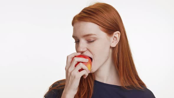 Cute Caucasian Teenage Foxy Girl in Dark Blue Tshirt Eating Apple Smiling Showing Ok on White alt
