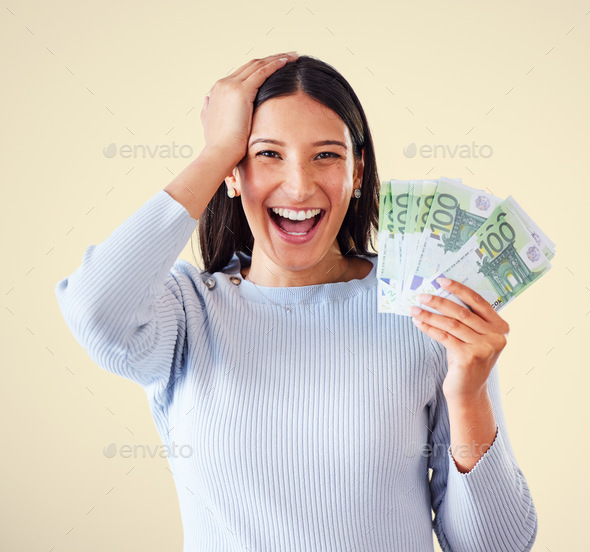 Woman celebrating success, winning money or lottery victory, holding cash or banknotes in hand. Por