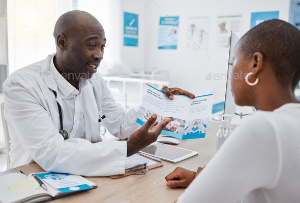 A doctor giving patient hospital information at a clinic and explaining medical benefits to a woman - Stock Photo - Images