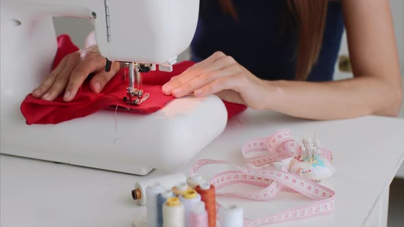 Tailor Woman is Creating New Clothes and Sewing on Sewing Machine at Table