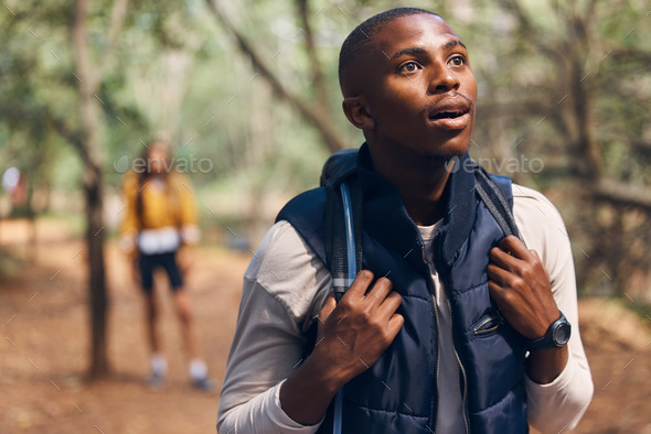 Hiking young black man in forest nature with wow face traveling with backpack in woods. Surprise, h
