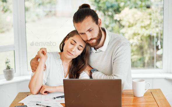Support, couple and finances while embracing each other and sitting with papers and a laptop for bi
