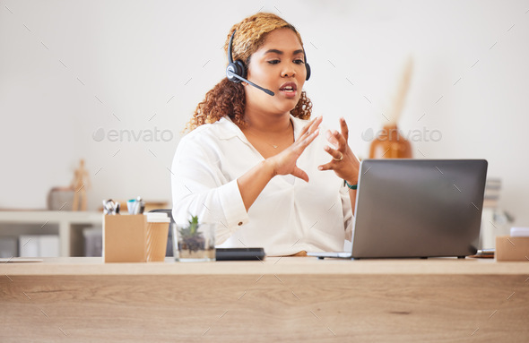 Female call center agent talking on headset while doing a video or zoom call and working in an offi