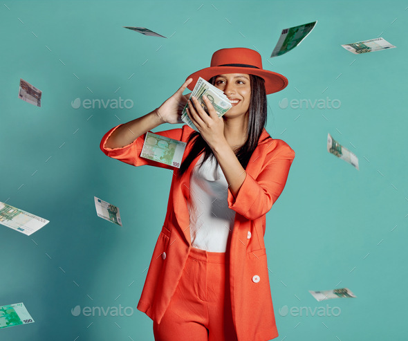 Trendy, confident and happy woman throwing money and spending away as she shows off her wealth afte