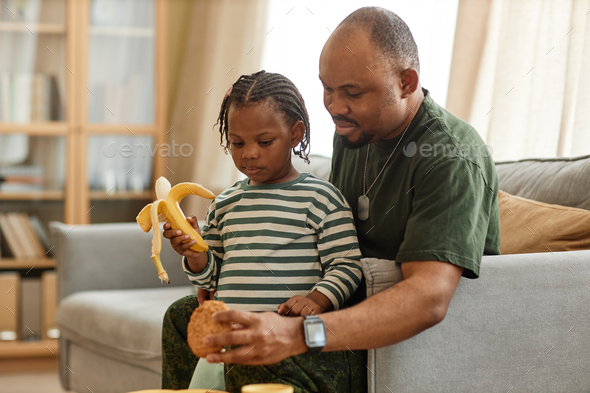 Military dad sharing breakfast with cute daughter at home