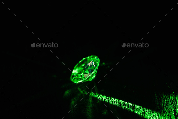 illuminated diamond with bright green neon ray on dark background
