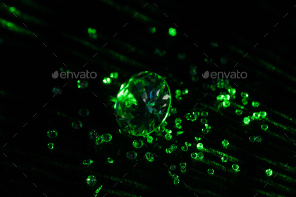 collection of diamonds with bright green neon light on dark background