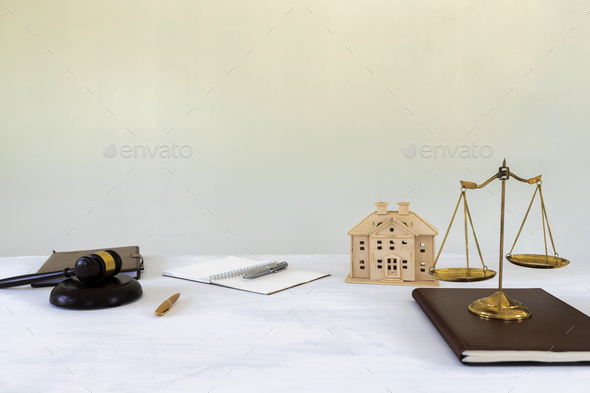 Gold brass balance scale with gavel and House model. housing and real estate law.