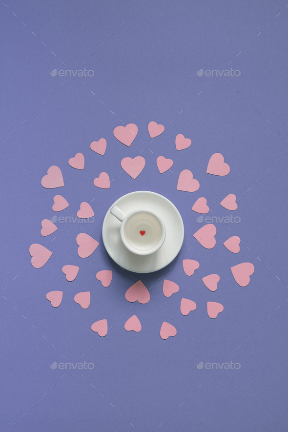 White cup with small red heart-shaped candy on the bottom. - Stock Photo - Images