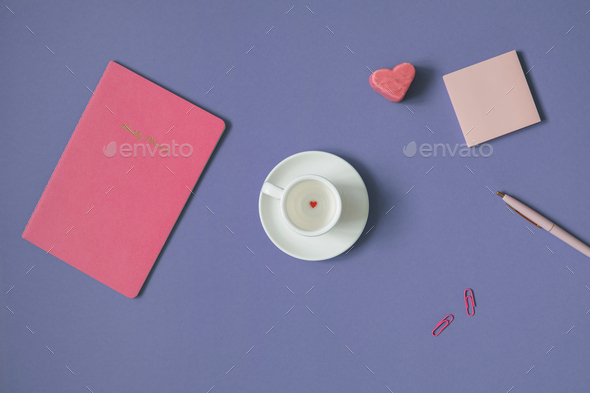 Weekly planner, blank paper sheets, stationery, white cup with small red heart-shaped candy on the b - Stock Photo - Images