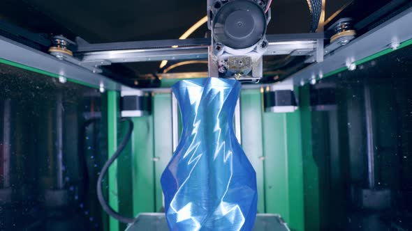 Hightech Machine is Printing a Blue Vase in 3D alt