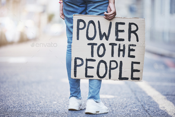 Power to the people cardboard protest poster in a city street for politics, government or human rig