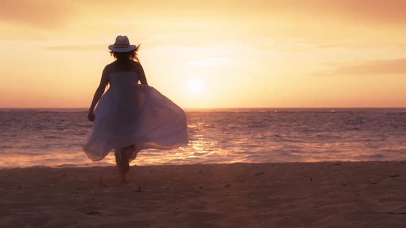 Young Bride in White Flying Wedding Dress Running Barefoot By Beach to Sunset alt