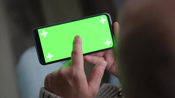 Close Up of Man Hand is Holding Chroma Key Green Screen in Horizontal Position Touching Swiping alt