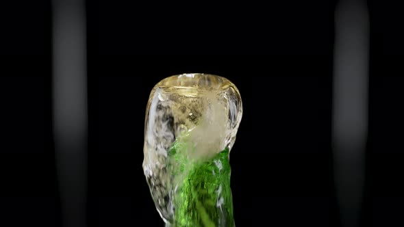 Macro Shot of Cap Popping Out of Green Glass Bottle and Explosion of Splash Carbonated Beer alt