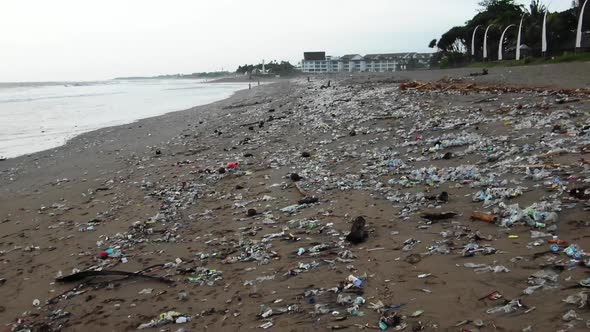 Pull back shot of a disgustingly polluted beach, plastic waste dumped in the ocean washed out by the alt