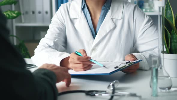 A Female Doctor Holds A Tablet With Tests And Consults A Patient In The Hospital. The Doctor alt