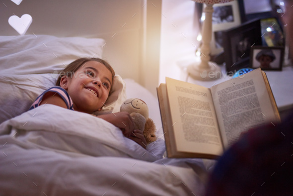 Did they live happily ever after. Shot of a father reading a bedtime story to his daughter.