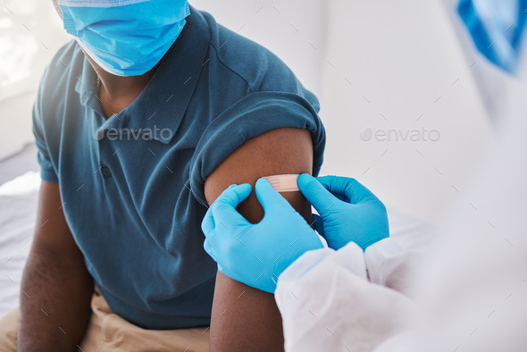 Medical doctor, registered nurse or healthcare professional placing plaster on arm after injecting