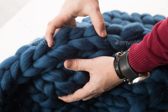 blanket made of natural sheep wool of coarse knit in men's hands