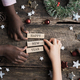 Hands of caucasian and black children making a Happy new year sign spelled on wooden pegs - PhotoDune Item for Sale