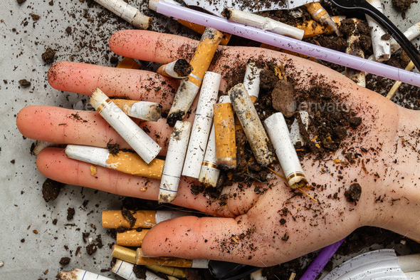 Close up hand holding pile of cigarettes with dirt. - Stock Photo - Images