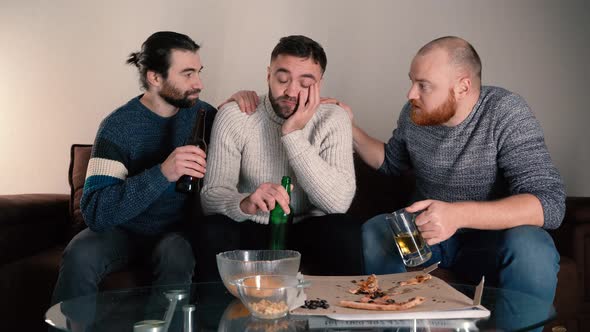 Unhappy Stressed Guy Drinking Beer Sitting on Sofa with Friends alt
