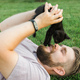 Close-up of Man with little kitten lying and playing on grass - friendship love animals and pet - PhotoDune Item for Sale