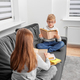 Children read books in eyeglasses sitting on sofa in room. Brother and sister are studying homework. - PhotoDune Item for Sale