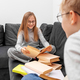 Children read books in eyeglasses sitting on sofa in room. Brother and sister are studying homework - PhotoDune Item for Sale